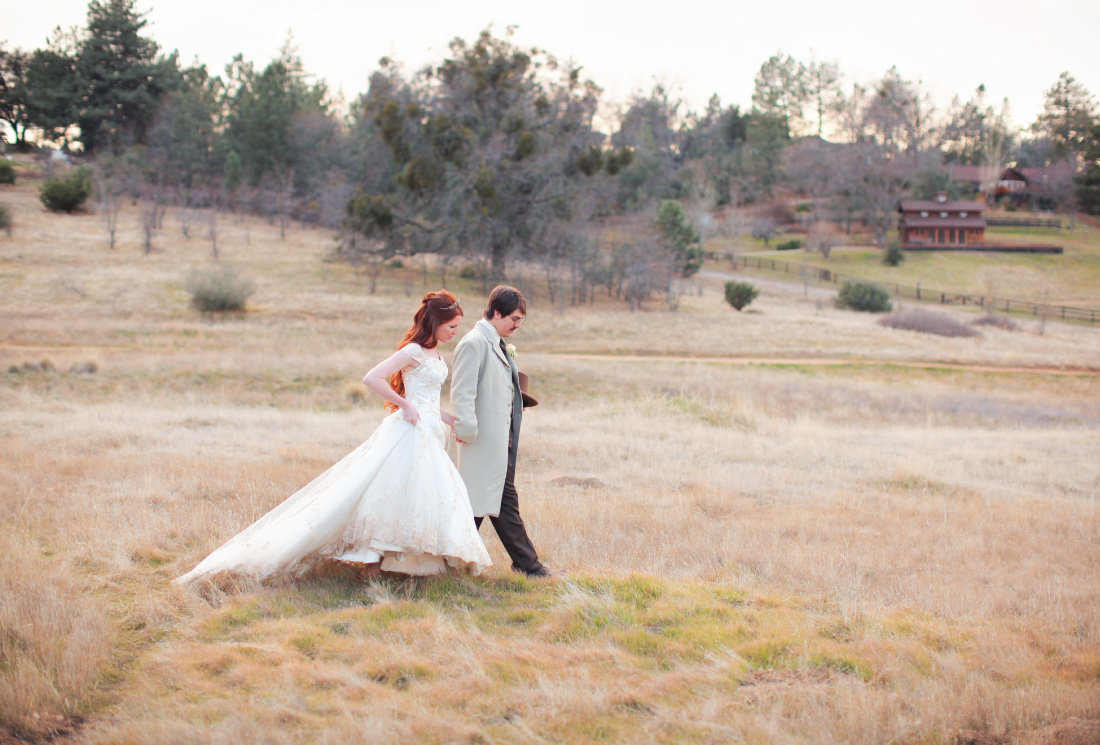 bride and groom strolling in an open meadow at the Julian Meadow View Inn